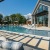 Pool side lounge chairs, exterior of clubhouse and outdoor showers